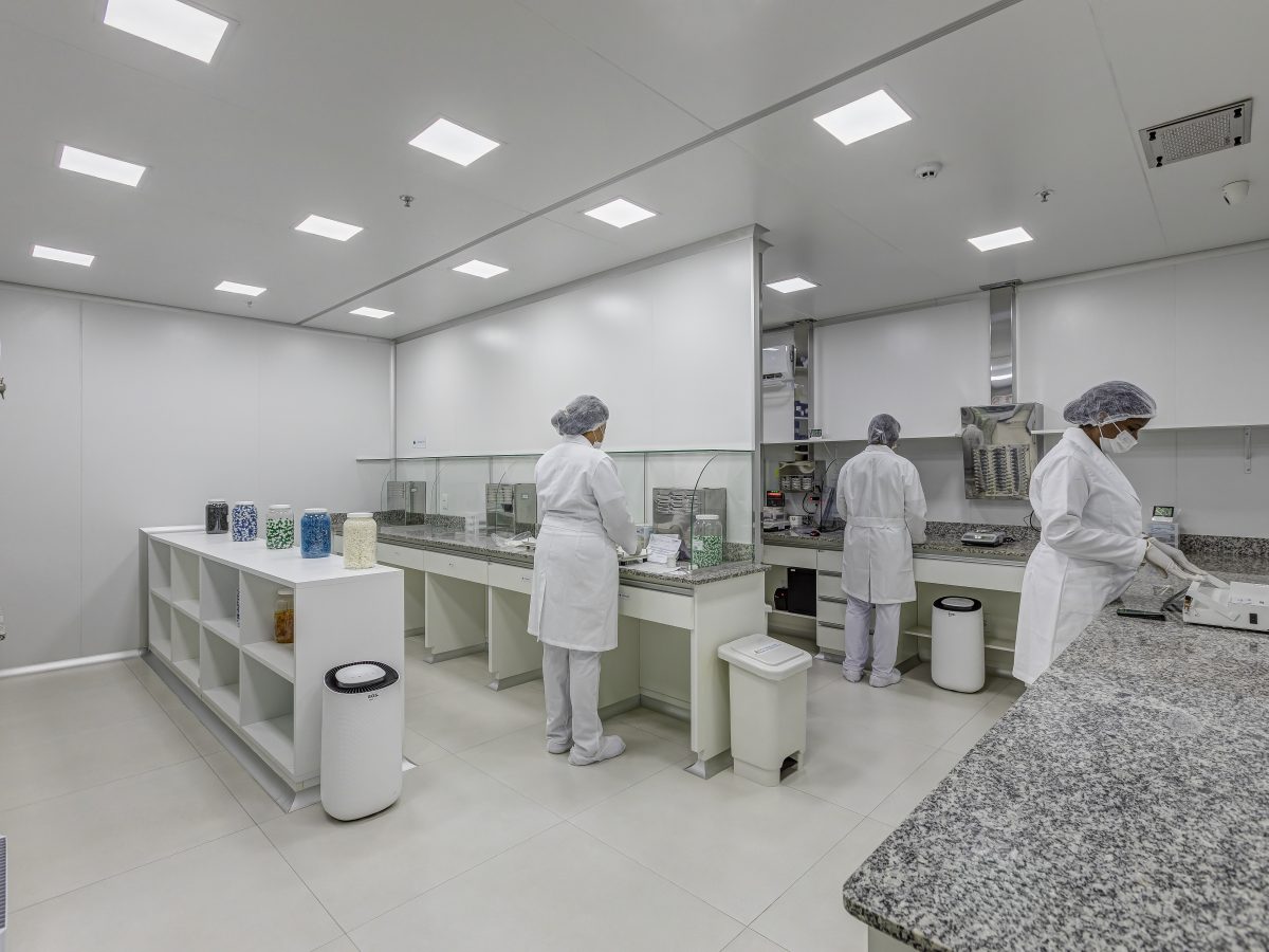 Equipe paramentada trabalhando nas bancadas do laboratório de manipulação